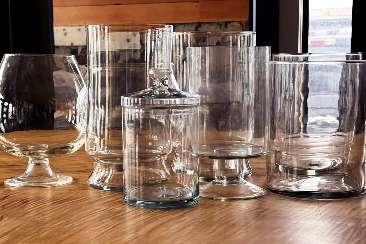 Clear glass terrarium vessels at INSIDE: a snifter, tall cylinders, a footed glass and a lidded jar.