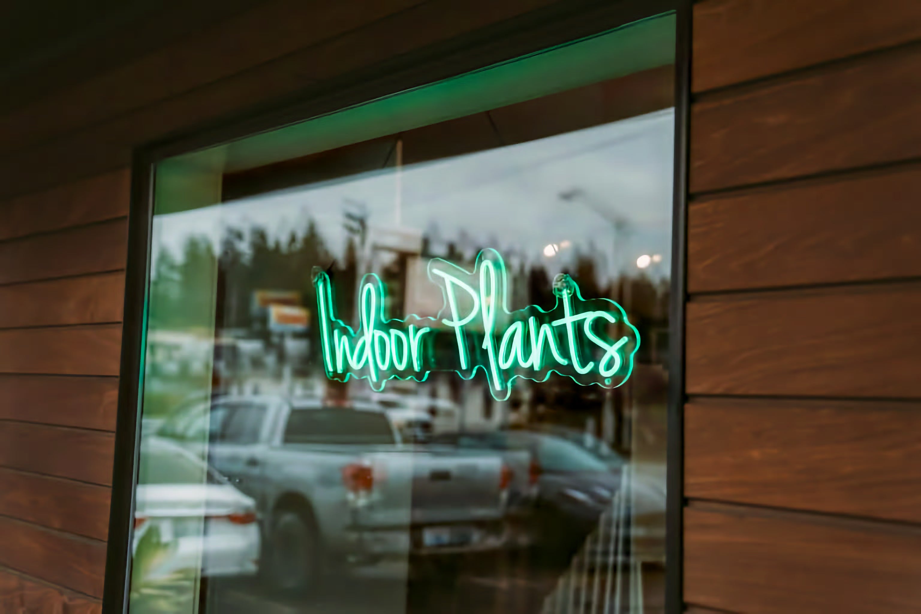 An "Indoor Plants" neon sign glowing in the window at INSIDE in Port Angeles